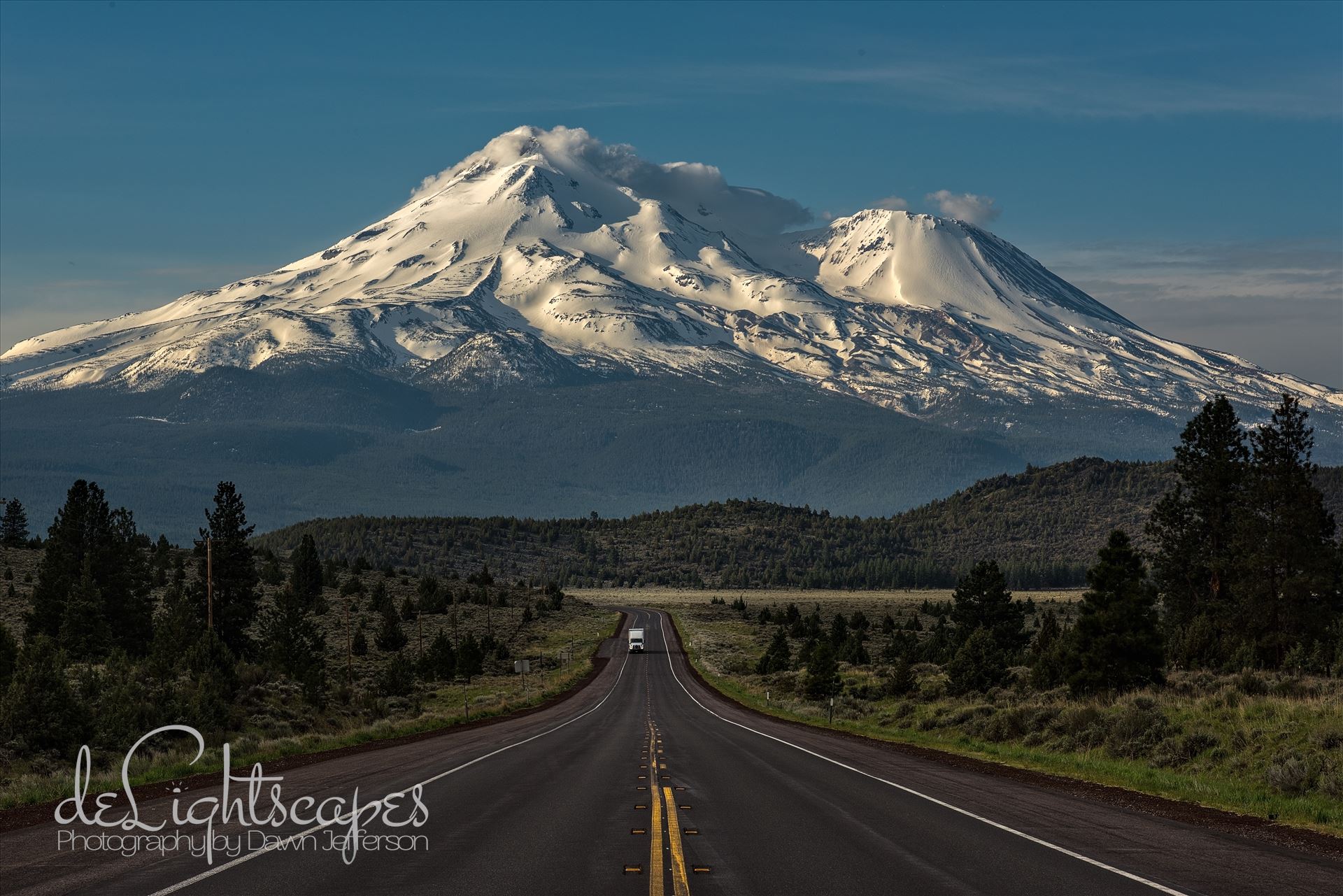Caution: Volcano Ahead - Mt Shasta is the 5th highest peak in California. It rises abruptly to 14,179 ft. Most prominently seen are the main summit and the satellite cone known as Shastina. by Dawn Jefferson